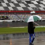 A crew member walks down pit road as officials hope to start the rain-postponed NASCAR Daytona 500 Sprint Cup series auto race in Daytona Beach, Fla., Monday, Feb. 27, 2012. NASCAR president Mike Helton says the Daytona 500 will start Monday night at 7 p.m. Heavy rain soaked Daytona International Speedway on Sunday, forcing NASCAR to postpone the event for the first time in its 54-year history.(AP Photo/Terry Renna)